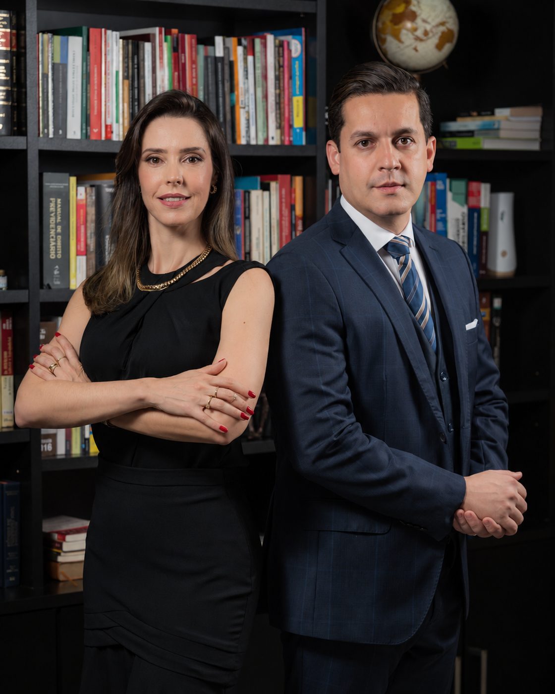 Moisés Daniel Furlan e Veridiana Furlan diante da estante de obras jurídicas, na sede do escritório em Araras